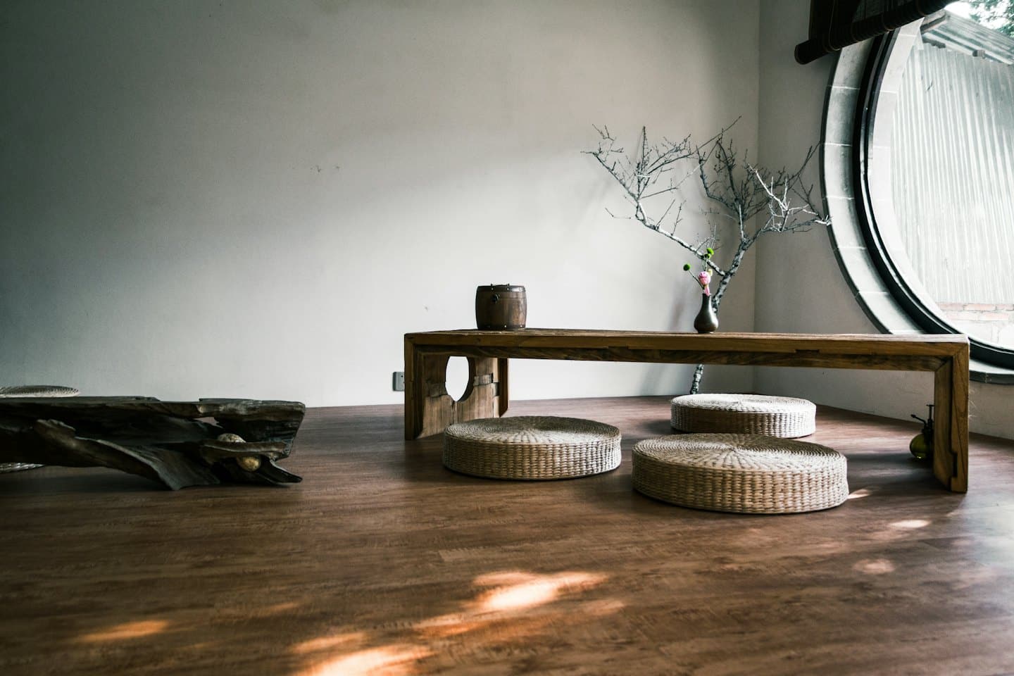 Prázdná meditační místnost s polštáři a svíčkami na podlaze.